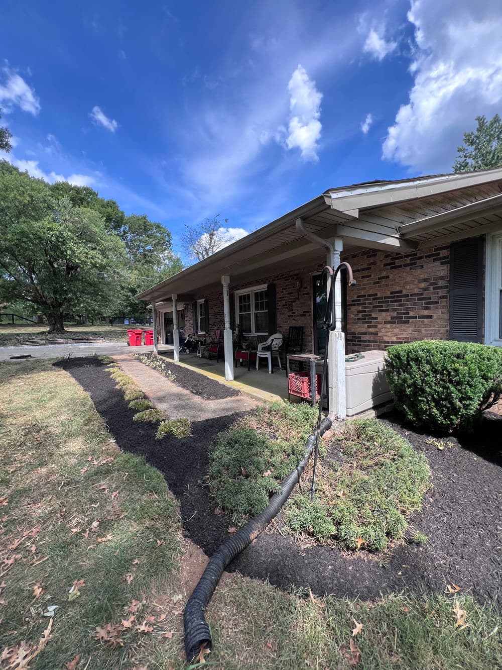 House exterior with landscaping, cloudy sky, and outdoor seating area visible.